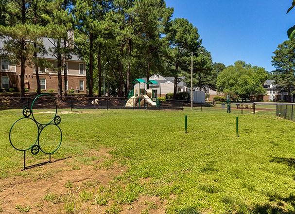 a park with a playground and a chain link fence