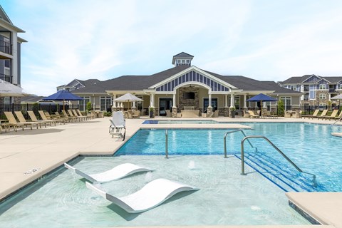 A large swimming pool with a slide and sun loungers.