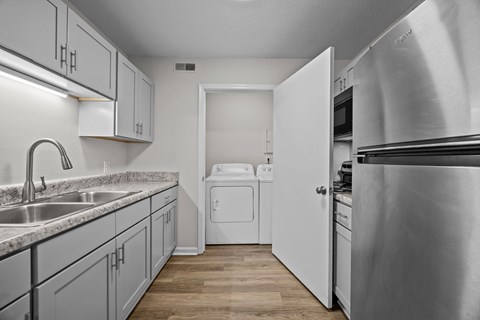 A kitchen with a stainless steel refrigerator and white appliances.