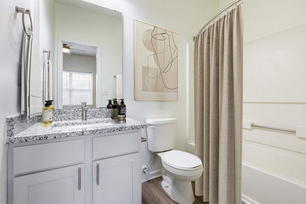 a bathroom with a toilet and a shower and a sink