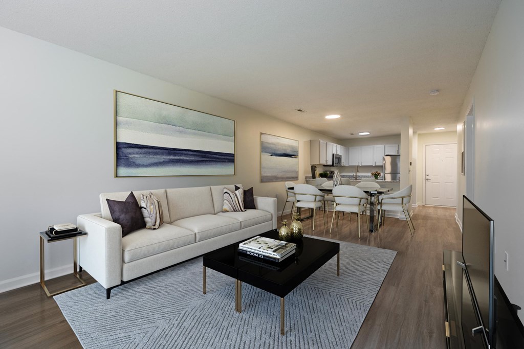 a living room with a couch and a coffee table in front of a dining room