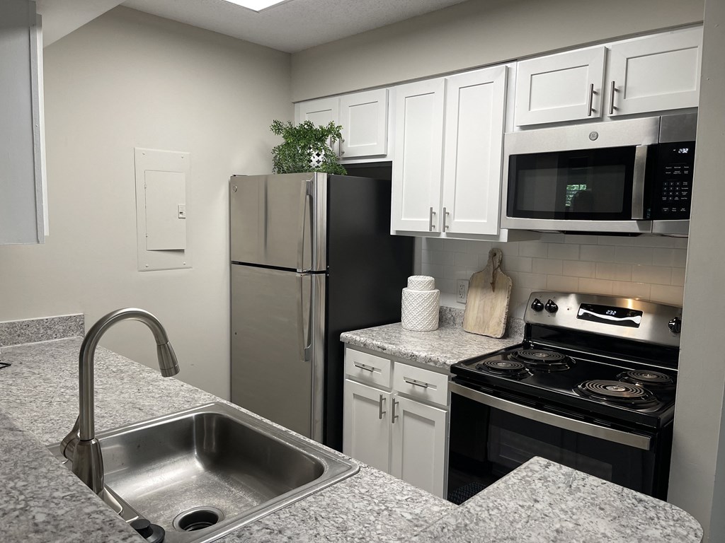 a kitchen with granite countertops and stainless steel appliances