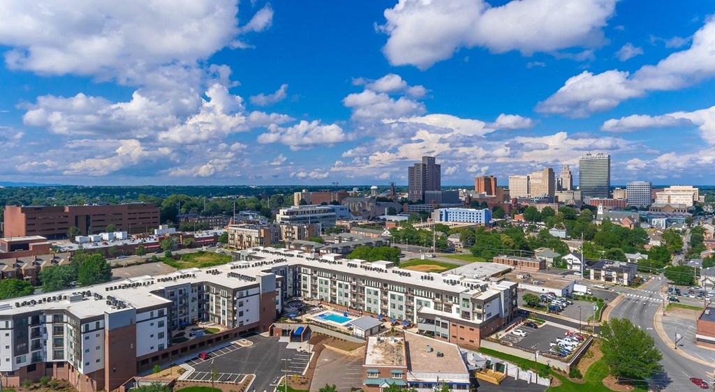 an aerial view of a city with a blue sky and clouds