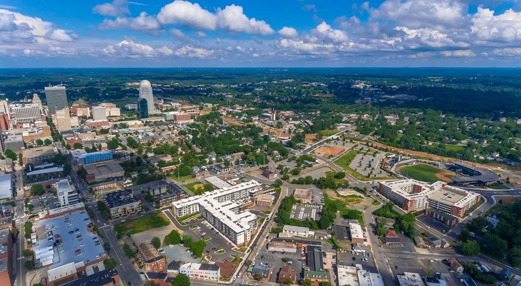 an aerial view of a city with a blue sky and clouds