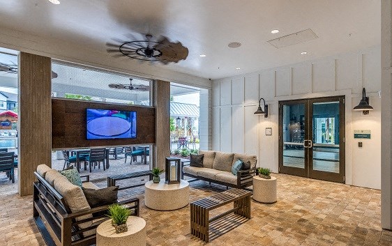 the lobby of a hotel with couches and a tv