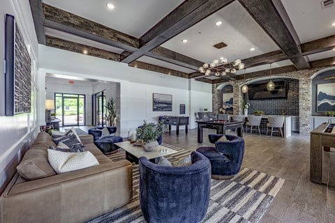 A living room with a brown couch and a chandelier.