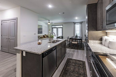 A modern kitchen with dark wood cabinets and a granite countertop.
