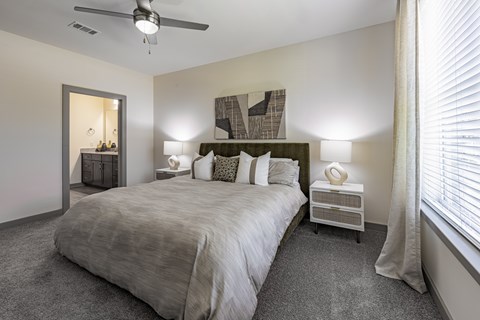 A bedroom with a large bed and a ceiling fan.