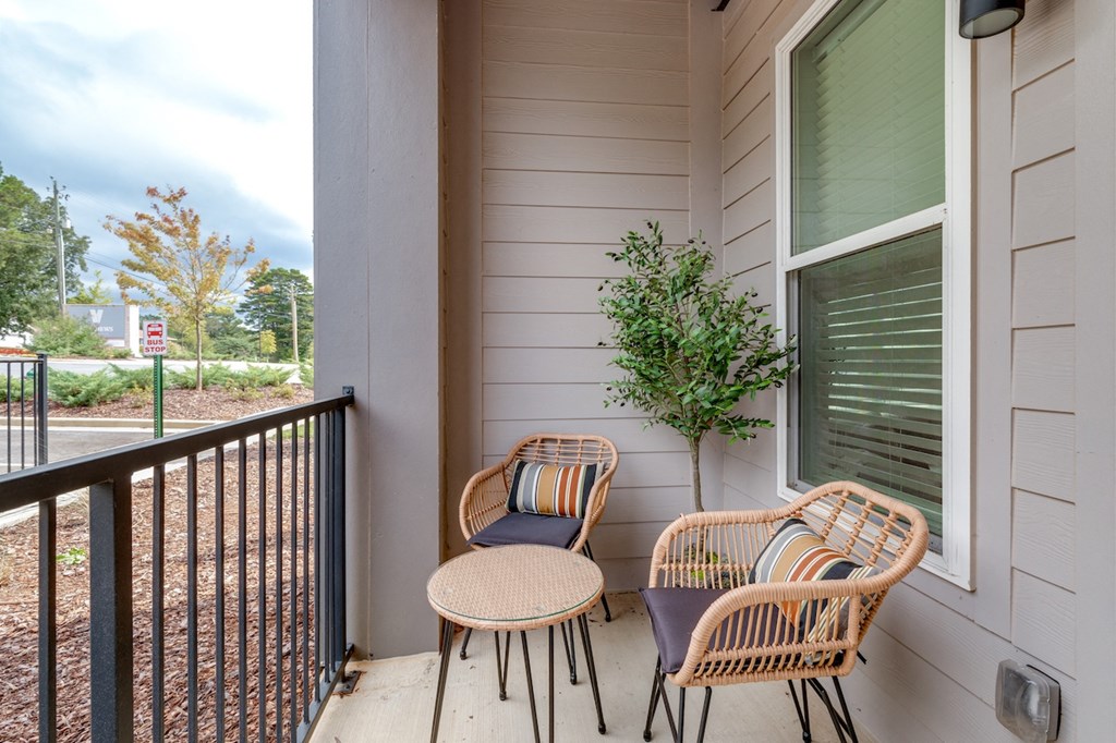 two chairs and a table on the porch of a house