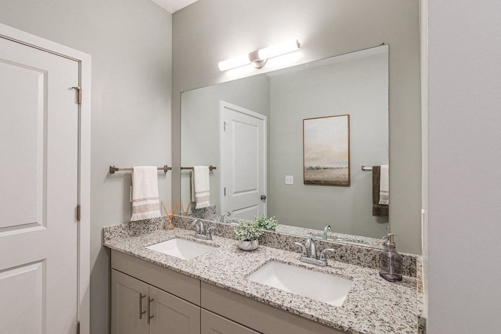 a bathroom with two sinks and a large mirror