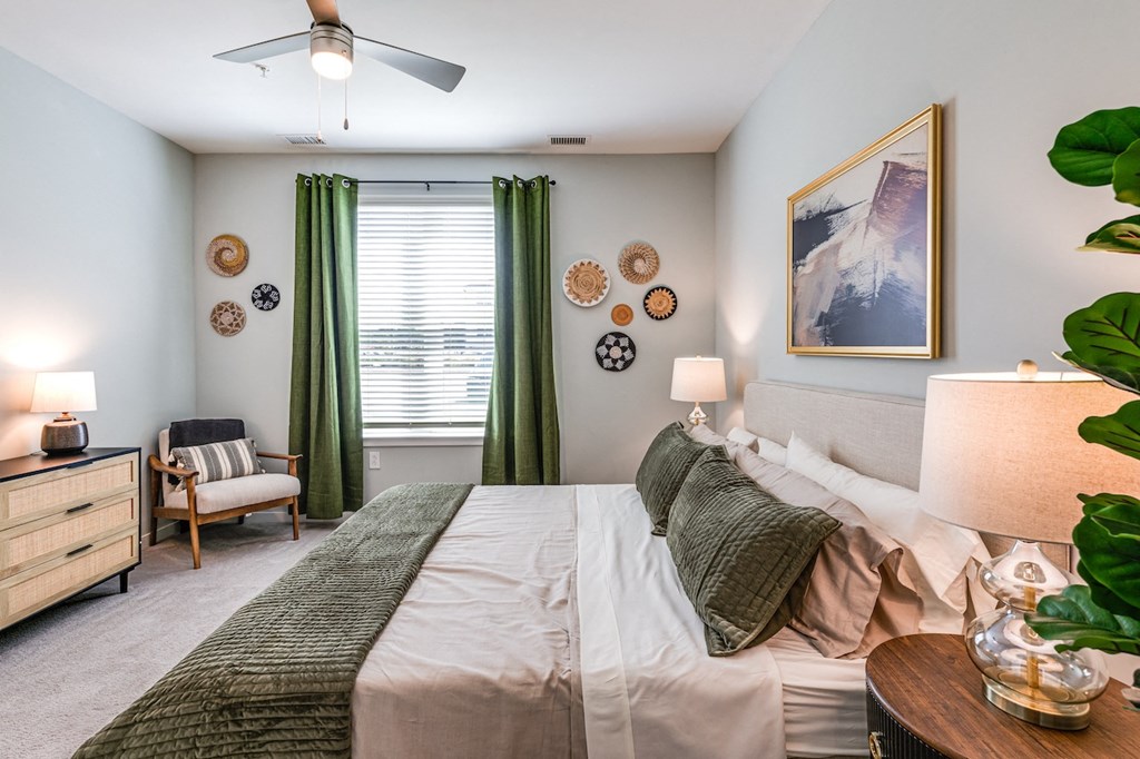 bedroom with a large bed and green curtains and a ceiling fan