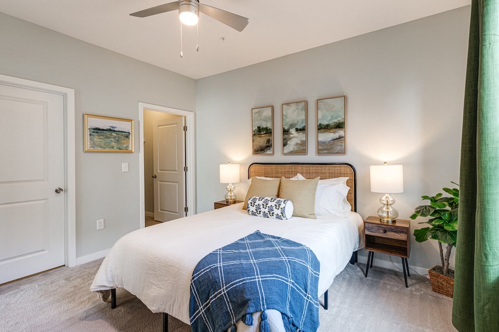 bedroom with a large bed and green curtains and a ceiling fan