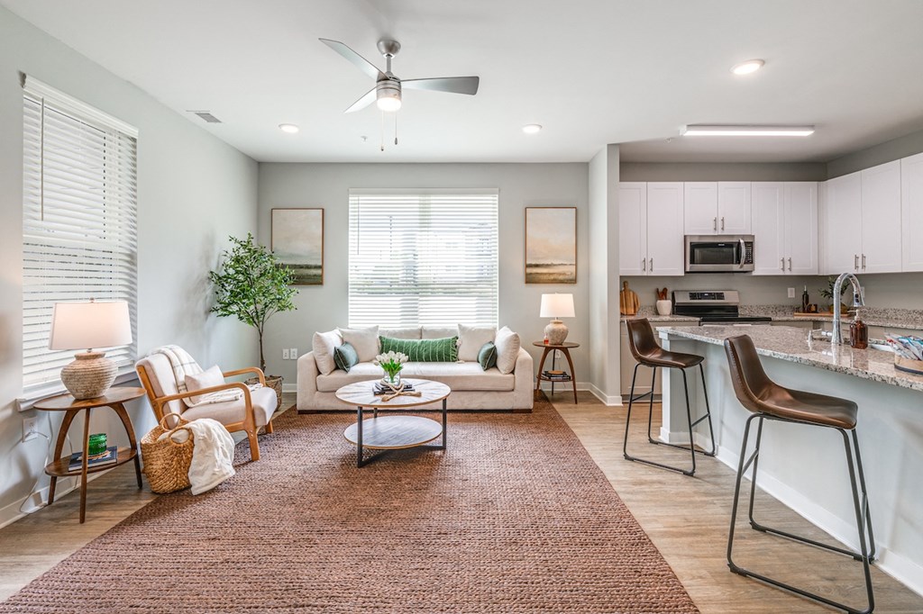a living room with a couch and a table in front of a kitchen