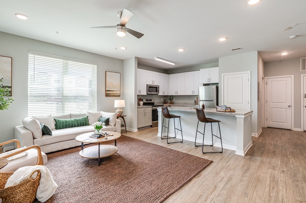 a living room with a couch and a kitchen with a bar