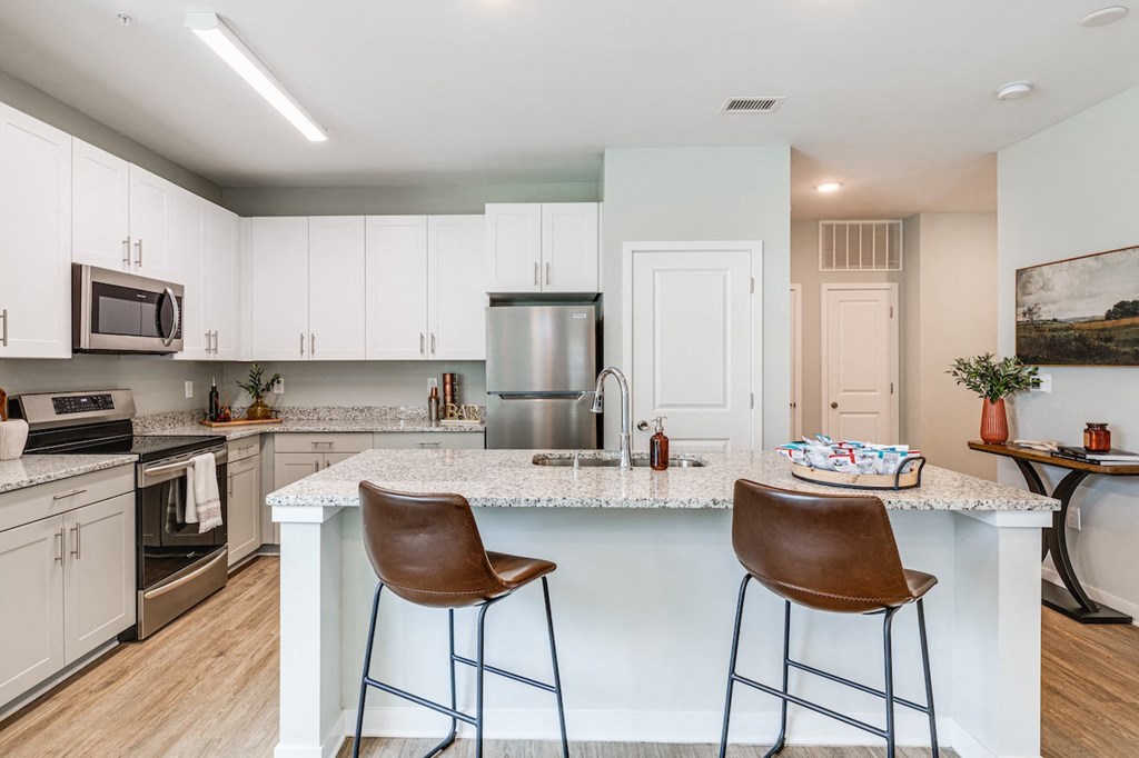 an open kitchen with a large island with two bar stools