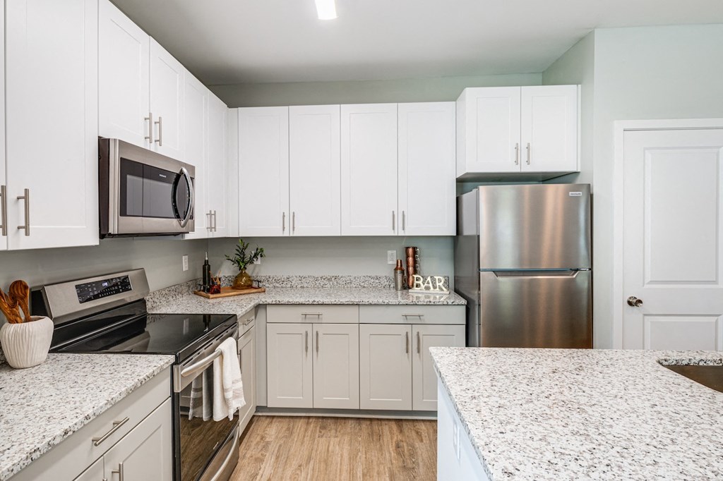 a kitchen with white cabinets and stainless steel appliances