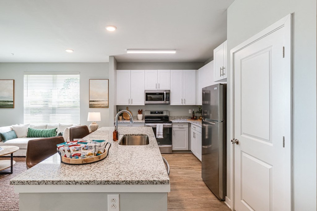 an open kitchen and living room with a granite counter top