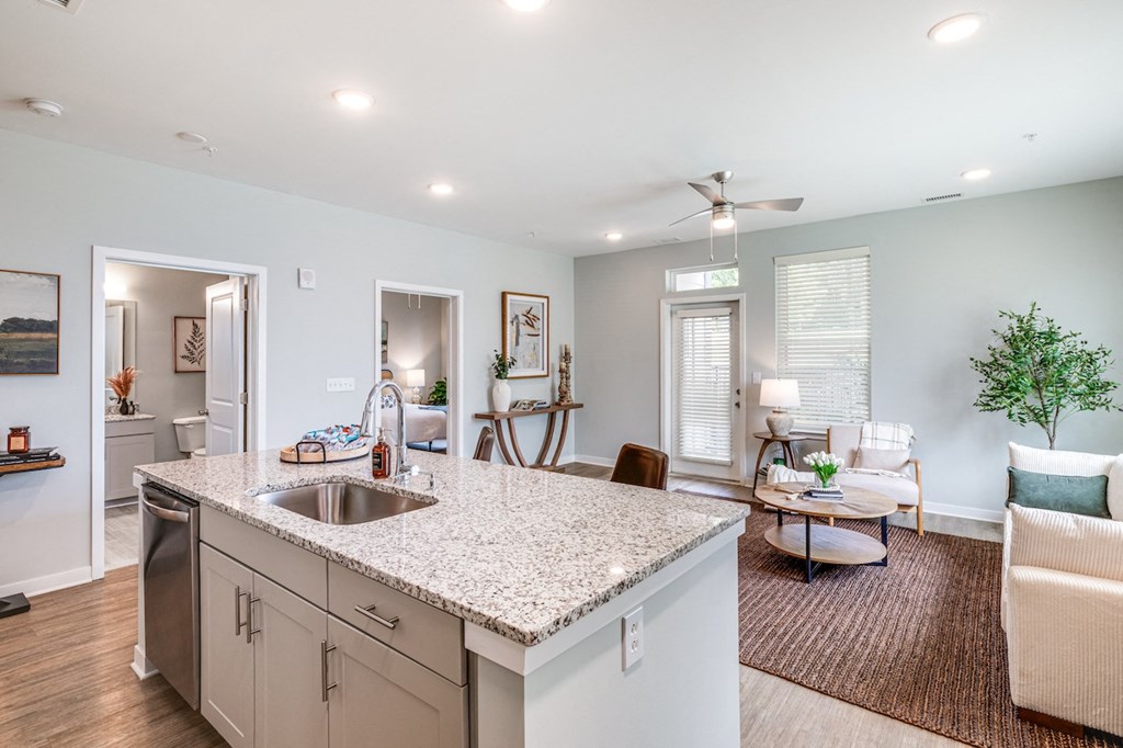 the view of a living room and a kitchen with a sink