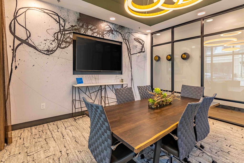 a conference room with a table and a tv