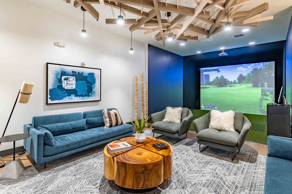 a living room with blue couches and a large screen tv