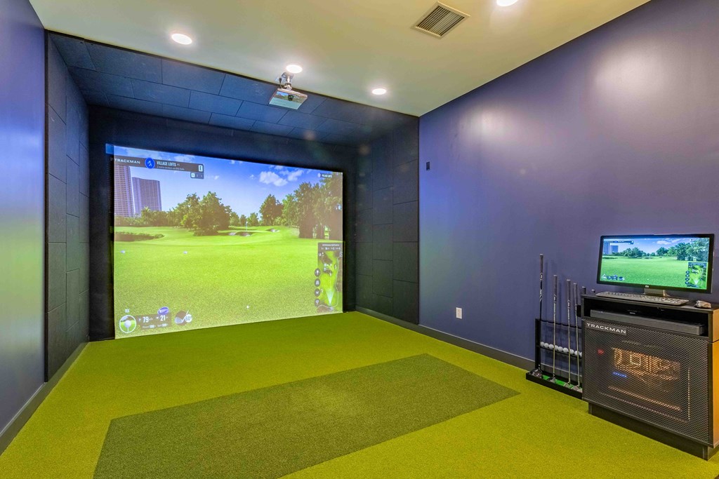 a game room with a large screen tv and a green carpet