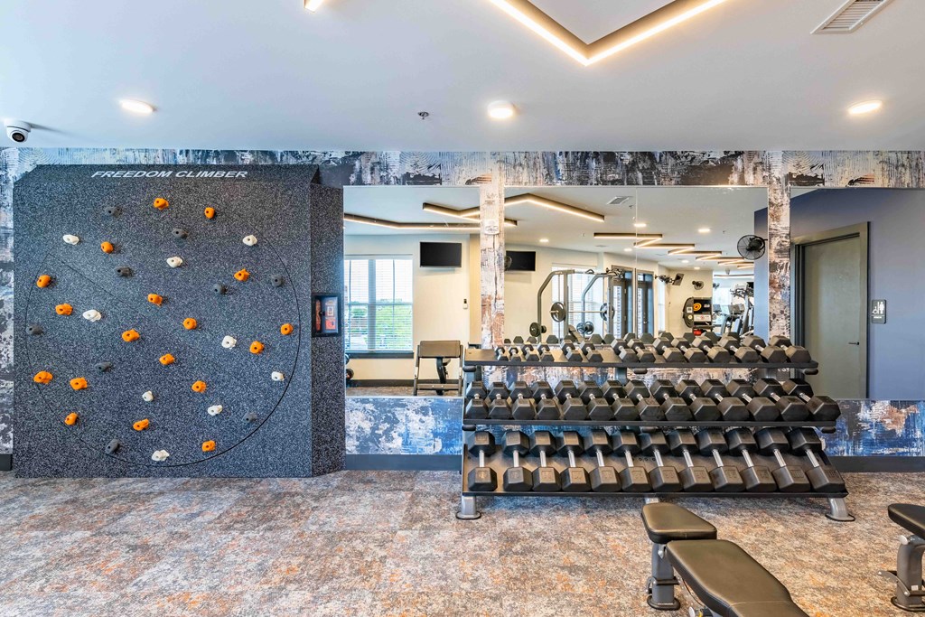a large training room with a large row of chairs and a rock climbing wall