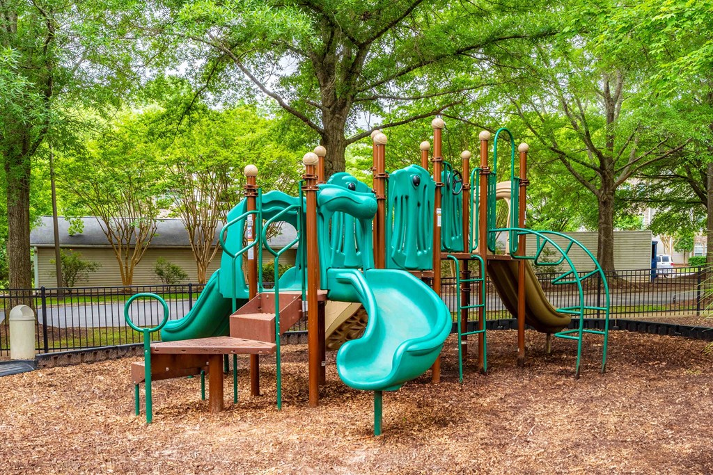 a playground with slides and benches in a park