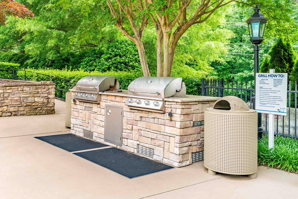 a stone barbecue grill in the middle of a park