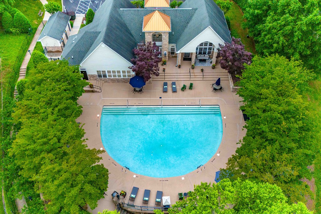an overhead view of a swimming pool in front of a house