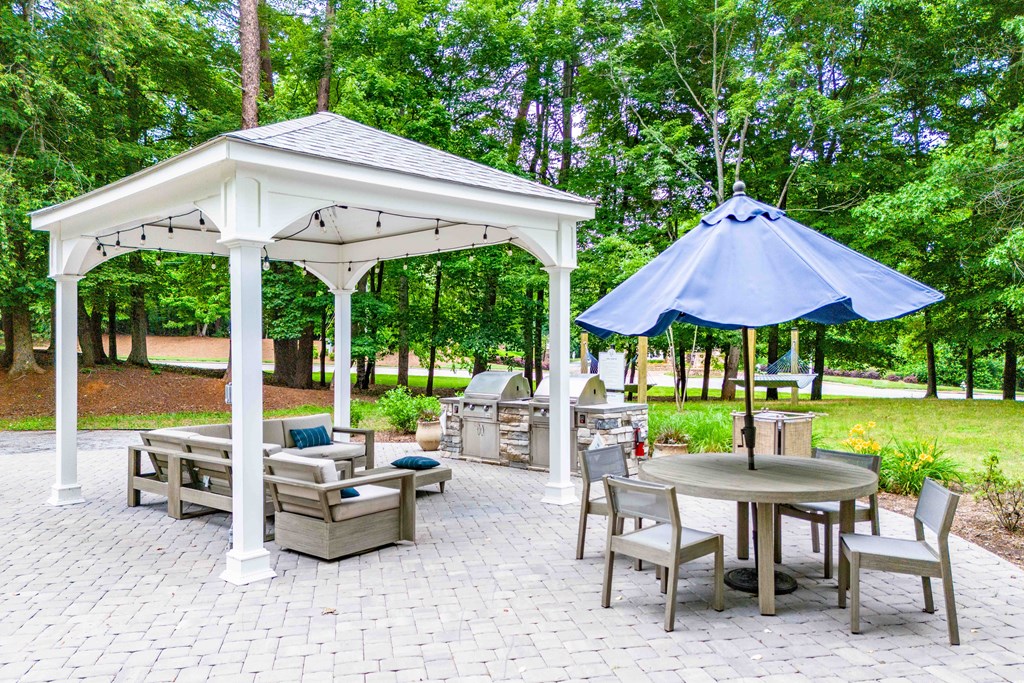 a patio with a pavilion and tables with umbrellas