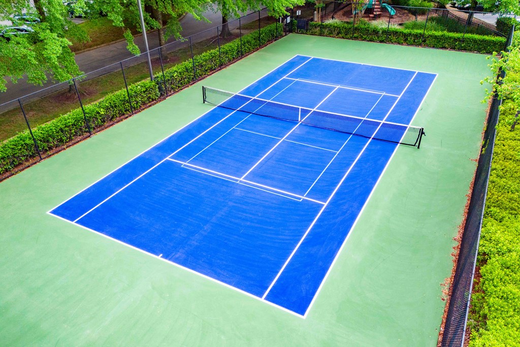 a blue tennis court on a green court