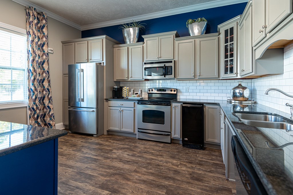 a kitchen with white cabinets and stainless steel appliances