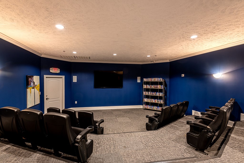 a blue screening room with chairs and a tv