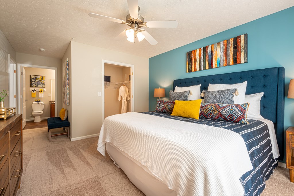 a bedroom with a large bed and a ceiling fan