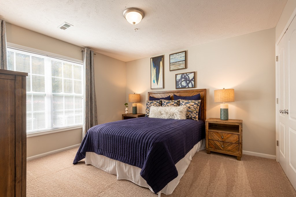 the master bedroom has plenty of windows and a large bed