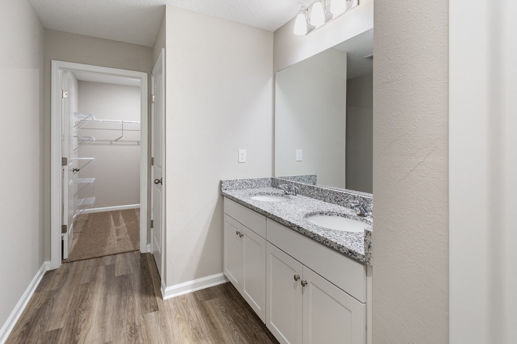 a bathroom with granite counter tops and a large mirror