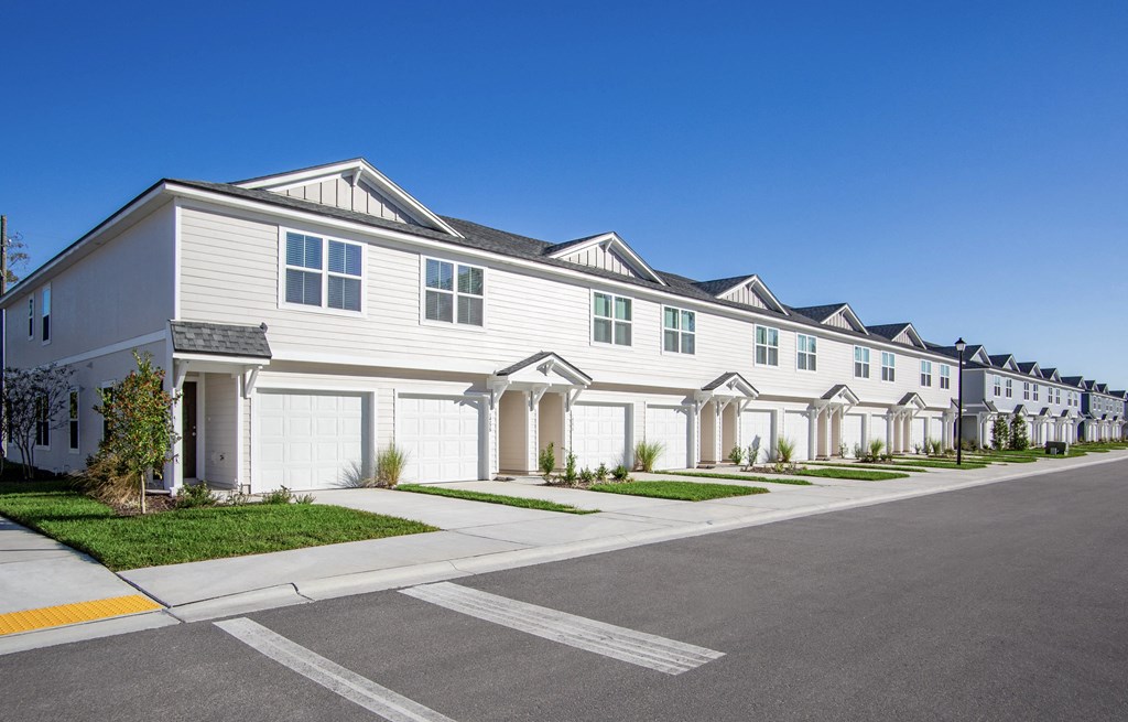 A row of houses with a street in front.