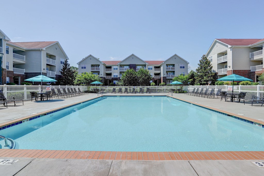 a swimming pool with apartment buildings in the background