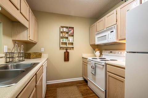 a kitchen with white appliances and wooden cabinets