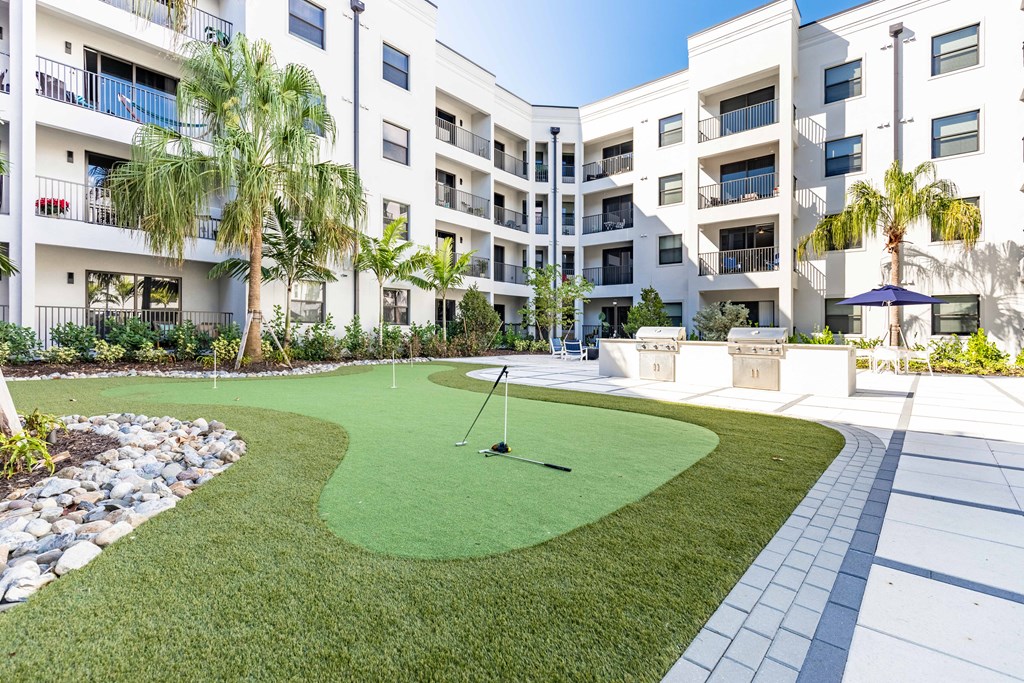 a putting green in front of an apartment building