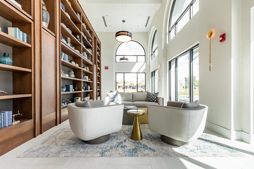 a living room with couches and chairs and a book shelf