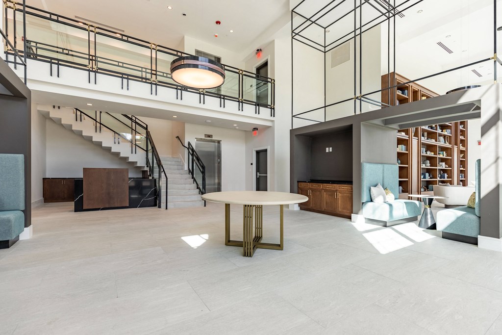 a living room with a round table and a staircase