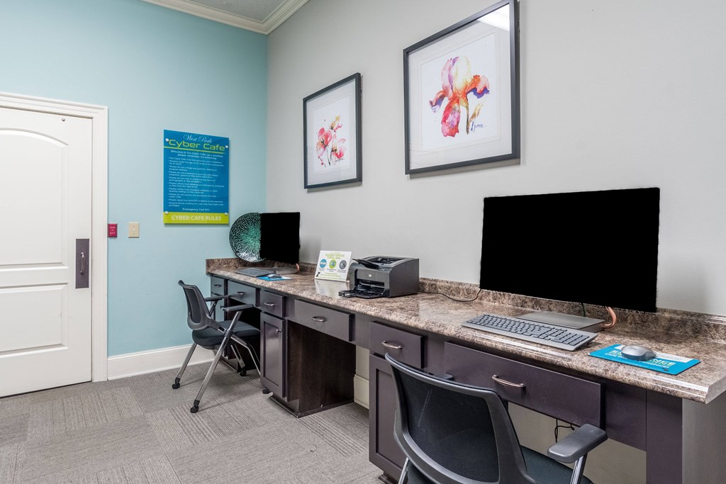 a office with two computers and a desk with chairs