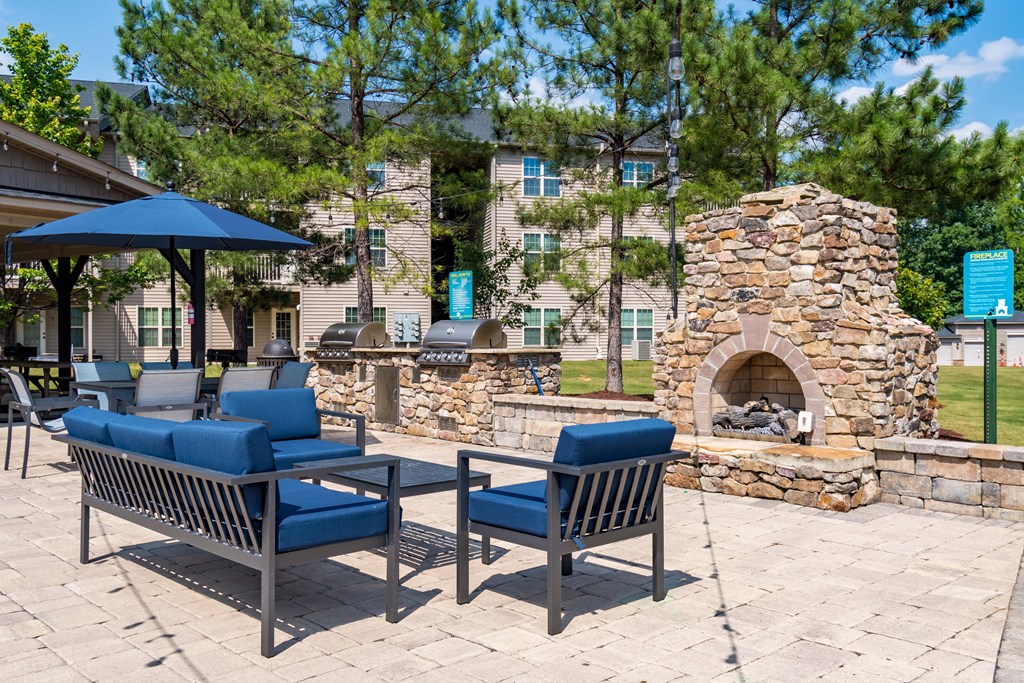 the preserve at ballantyne commons clubhouse with patio furniture and a stone fireplace