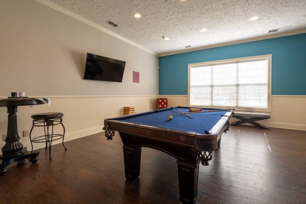 a game room with a pool table and a tv