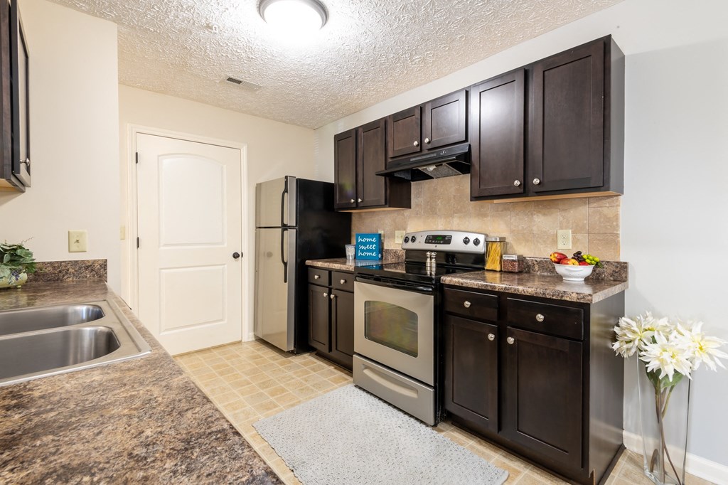 modern kitchen with dark brown cabinetry and stainless steel appliances