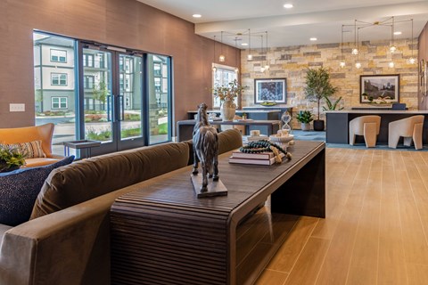 A living room with a brown couch and a statue on the coffee table.