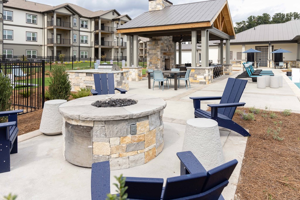 Patio with a fire pit and chairs for seating.