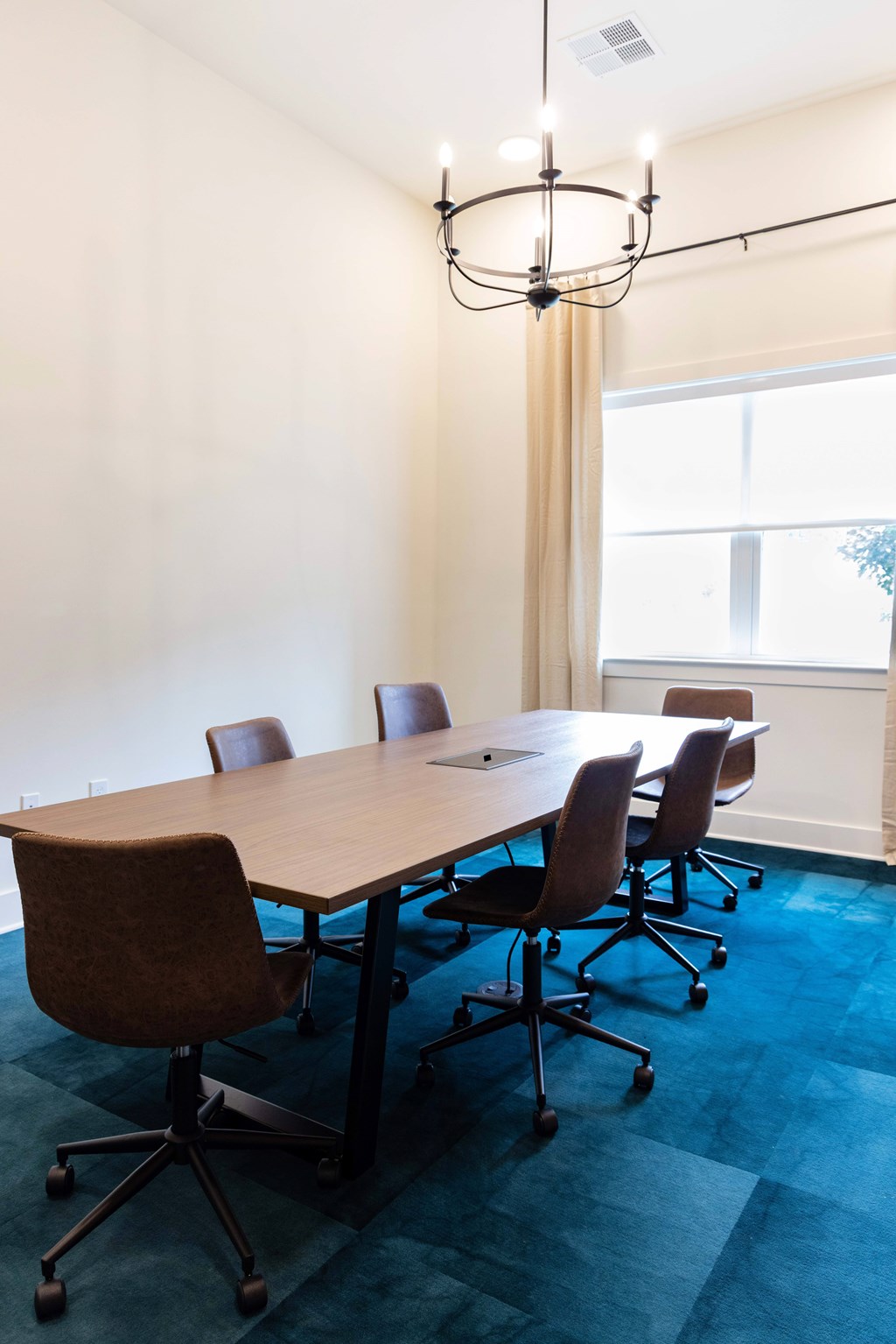 A conference room with a long table and chairs.