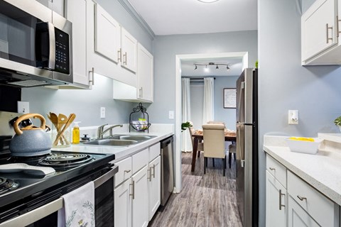 a kitchen with white cabinets and stainless steel appliances